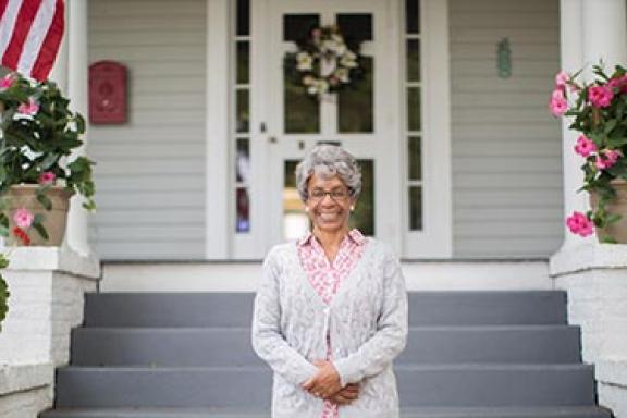 Old woman in front of a house